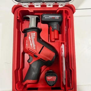 May include: A red Milwaukee Fuel Hackzall reciprocating saw kit in a red hard case. The kit includes the saw, a battery, a charger, and several saw blades. The saw has a black handle and the case has a clear lid.