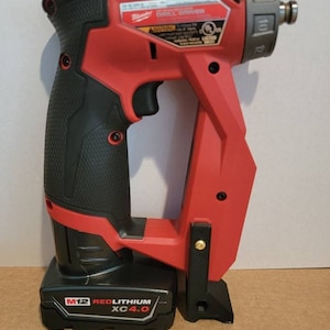 May include: A red and black cordless drill driver with a black battery pack labeled "M12 REDLITHIUM XC4.0".