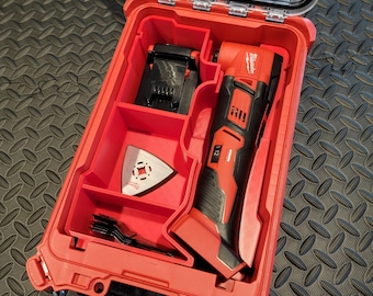 May include: A red and black Milwaukee multi-tool kit with a clear lid. The kit includes a multi-tool, blades, and a charger. The case is open, revealing the tools inside. The kit is designed for various cutting and sanding tasks.