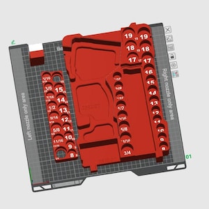 Puede incluir: Una pieza roja impresa en 3D con varios recortes circulares y rectangulares, etiquetados con números y fracciones. La pieza está diseñada para un área de boquilla y se encuentra sobre una superficie gris. El diseño incluye el texto "7892-20".