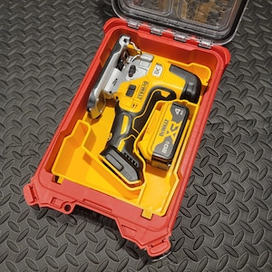 May include: A yellow and black cordless jigsaw with a 20V battery, nestled in a red and yellow plastic case. The case has a clear lid and is designed to protect the tool. The jigsaw is a power tool, ideal for cutting wood and other materials.