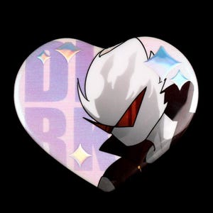 Peut inclure: Un badge en forme de cœur représentant un personnage blanc stylisé aux yeux en forme de visière rouge. Le fond présente un motif de grille violet clair avec le texte "DARK" partiellement visible et des étoiles iridescentes à quatre branches.
