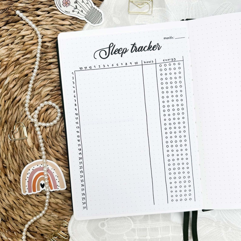 May include: A black and white sleep tracker with a grid for tracking hours of sleep and energy levels for each day of the month. The tracker has a heading that says "Sleep tracker" and a space to write in the month.