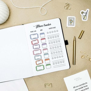 May include: A black and white planner with a movie tracker page. The page has a title "Movie Tracker" and includes sections for movie title, date, and rating. The rating section has five stars for each movie.