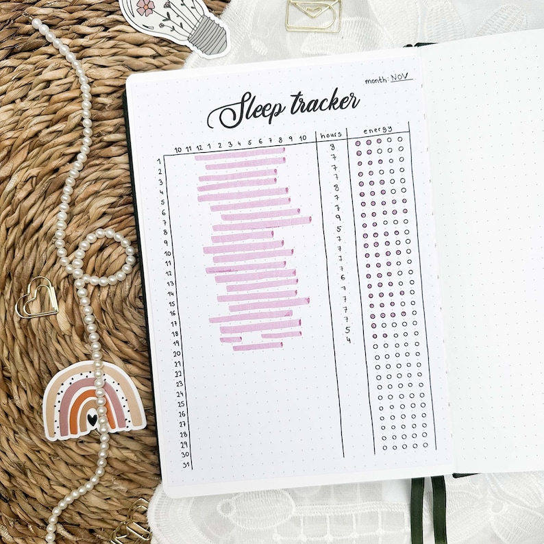 May include: A sleep tracker for the month of November. The tracker has a column for hours slept and a column for energy levels. The hours slept column has a pink bar graph showing the number of hours slept each day. The energy levels column has a grid of circles that can be filled in to indicate energy levels.
