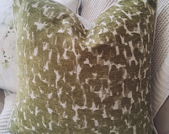 May include: A green and white patterned throw pillow with a white border. The pillow is made of a soft, textured fabric.