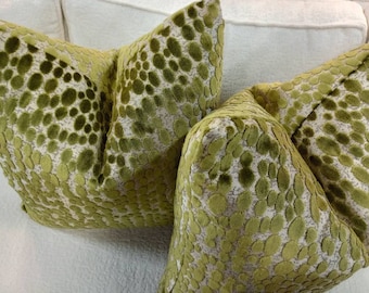 May include: Two green and white patterned throw pillows with a textured, raised design. The pillows are made of a soft, plush fabric.