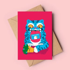 Może przedstawiać: Kartka okolicznościowa z kreskówkowym niebieskim tygrysem trzymającym czerwony prostokąt z ilustracją kaczki i napisem "HELLO FRIEND". Karta znajduje się na różowym tle z brązową kopertą.