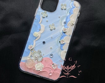 May include: A clear phone case with a blue and pink background. The case is decorated with white and pink 3D flowers, pearls, and glitter. The case is designed to fit an iPhone 11 Pro.
