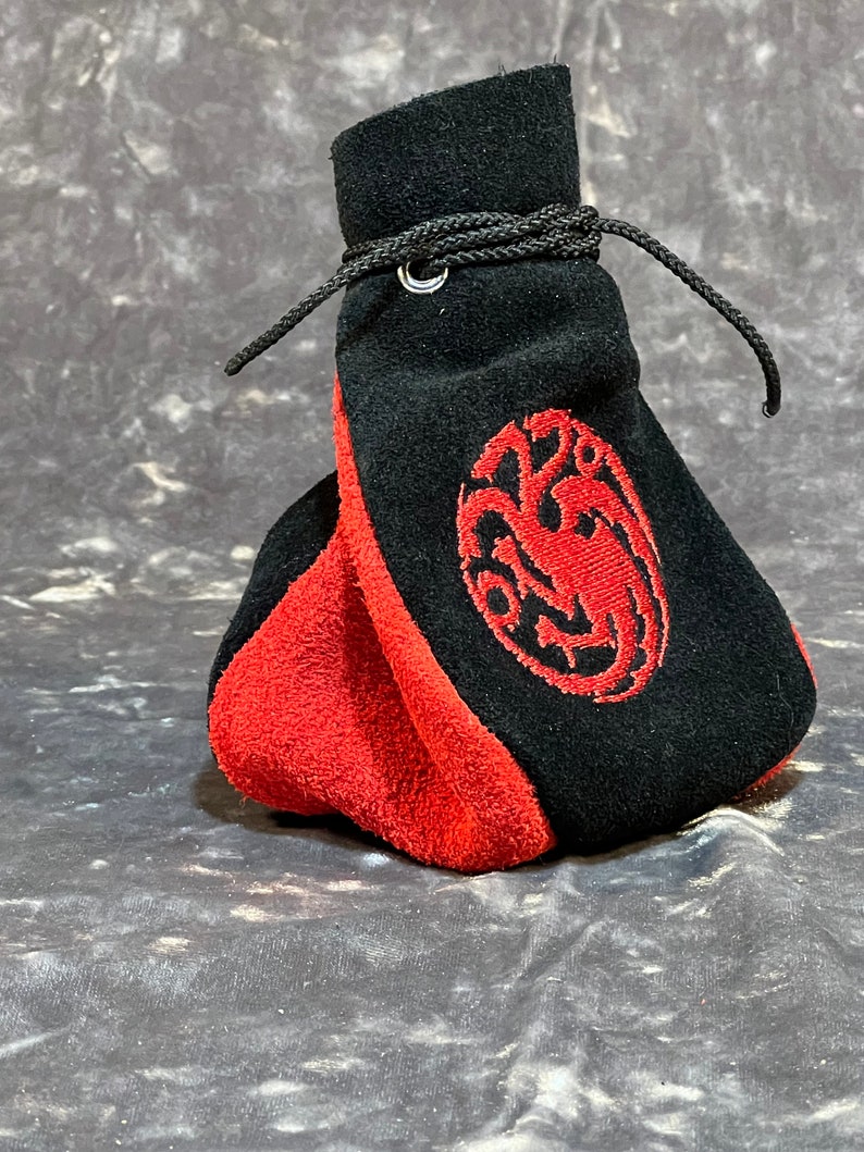 May include: A black and red suede drawstring bag with a red embroidered dragon design.