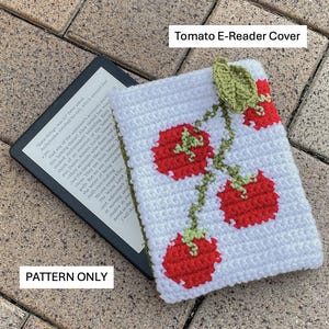 May include: White crochet e-reader cover with red tomato design and green vines. The cover has the text "Tomato E-Reader Cover" and "PATTERN ONLY". The cover is designed to protect an e-reader.