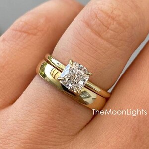 Peut inclure: Une alliance de mariage en or avec un diamant central de forme coussin. La bande est un design simple et classique.