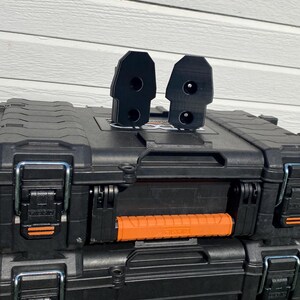 May include: Black toolboxes with orange accents and the "RIDGID PRO GEAR SYSTEM GEN 2.0" logo. Two black attachments are on top of the toolbox. The toolboxes are stacked on top of each other.
