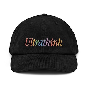 Peut inclure: Casquette de baseball en velours côtelé noir avec le mot "Ultrathink" brodé en couleurs arc-en-ciel sur le devant. La casquette a une visière incurvée et une couronne structurée. Un accessoire décontracté.
