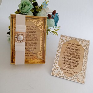 May include: Two wooden plaques with gold accents and intricate designs. The plaques feature the Arabic text of Ayatul Kursi, a verse from the Quran, and the names "Tasnem & Omar" and the date "12.09.2021".