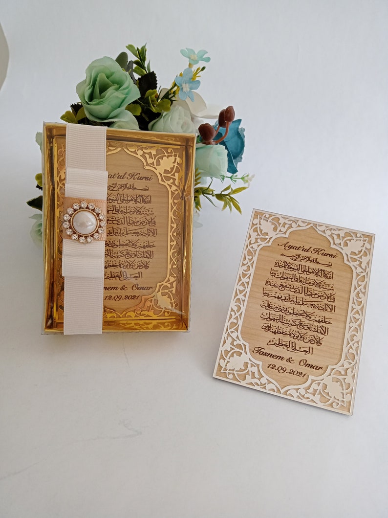 May include: Two wooden plaques with gold accents and intricate designs. The plaques feature the Arabic text of Ayatul Kursi, a verse from the Quran, and the names "Tasnem & Omar" and the date "12.09.2021".