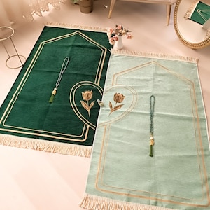 May include: Two prayer rugs with gold trim and floral designs. One rug is green and the other is light green.