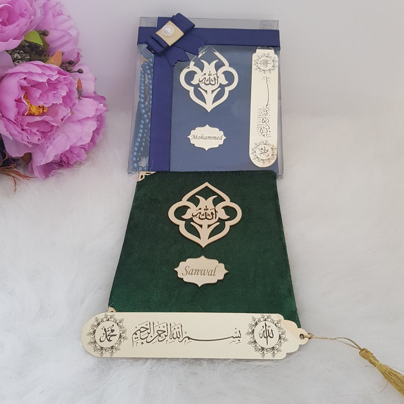 Puede incluir: Un libro cubierto de terciopelo verde oscuro con un emblema de metal dorado con caligraf&iacute;a &aacute;rabe y una placa con el nombre Sanwal. Un marcap&aacute;ginas de metal dorado con escritura &aacute;rabe y una borla est&aacute; sujeto al borde inferior del libro.