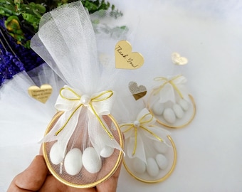Elegante detalle de boda con tul y caramelos de almendra.