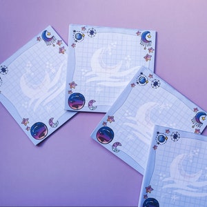 Può includere: Quattro fogli di blocco note blu e bianchi con un design di luna e stelle. I fogli hanno un motivo a griglia e sono decorati con lune crescenti, stelle e pianeti.