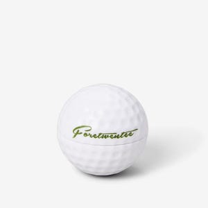 May include: White golf ball with the text "Fore!twenteee" in green lettering.