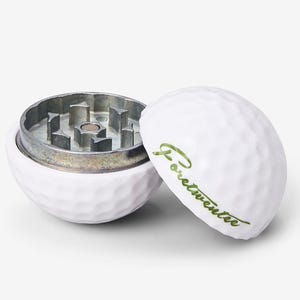 May include: White golf ball shaped grinder with a silver metal grinding mechanism. The top of the grinder has the word "Fortwente" written in green.