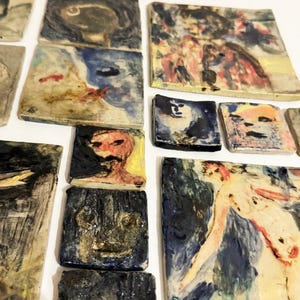 May include: A collection of square and rectangular ceramic tiles featuring hand-painted abstract and figurative designs in various colours including blue, yellow, red, and black. The tiles have a textured, glossy finish with visible brushstrokes.