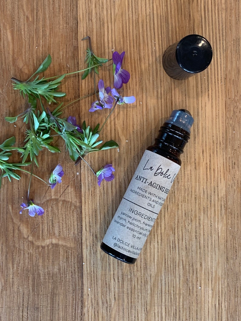 Puede incluir: Un frasco de vidrio marr&oacute;n con una tapa negra y una etiqueta blanca que dice "La Dolce Villa Anti-Aging Serum Made with Natural Ingredients and Essential Oils Ingredients: Yarrow Pom, Frankincense, Myrrh, Helichrysum, Lavender Essential Oils 10 ml @ladolcevilla"