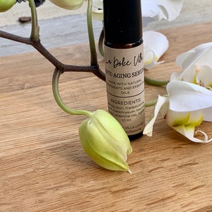 Puede incluir: Un frasco de vidrio marr&oacute;n con un tap&oacute;n negro y una etiqueta blanca que dice "La Dolce Vita Anti-Aging Serum Made with Natural Ingredients and Essential Oils Ingredients: Myrrh, Frankincense, Helichrysum, Tea Tree, Jojoba Essential Oils, 10 ml Villa Living villaliving"