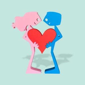 Sculpture of man and woman united by heart symbolic love art
