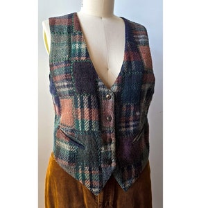 May include: A brown, green, and purple plaid vest with a V-neck and button closure.