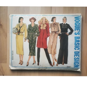 May include: A vintage Vogue's Basic Design sewing pattern featuring four different dress designs. The pattern is for size 2002 and includes instructions for making a yellow skirt with a black tie, a green floral dress, a red coat, a striped dress, and a black skirt with a white collar.