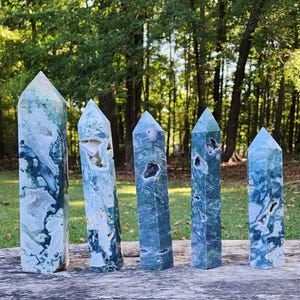 May include: Five green and white agate crystal points of varying sizes. The points are smooth and polished, with a natural, organic look.