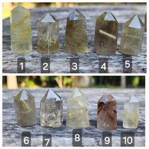 May include: Ten clear quartz crystal points with golden rutile inclusions. The crystals are arranged in two rows of five, numbered 1 through 10.