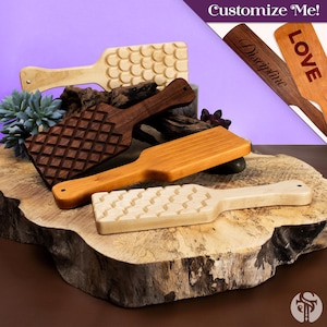 May include: Four wooden paddles with handles, featuring various textures including a grid pattern, a scale-like design, and smooth surfaces. Two additional wooden paddles are shown in the upper right corner with the text Discipline and LOVE.