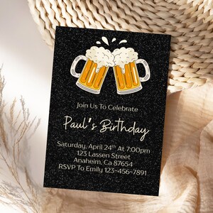 Peut inclure: Carte d'invitation noire avec deux chopes de bière de dessin animé qui s'entrechoquent. Le texte dit "Join Us To Celebrate Paul's Birthday" avec les détails de l'événement.