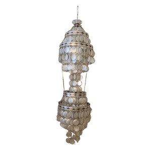 May include: A white shell chandelier with multiple tiers of round shells hanging from a metal chain. The chandelier has a gold-toned metal frame.