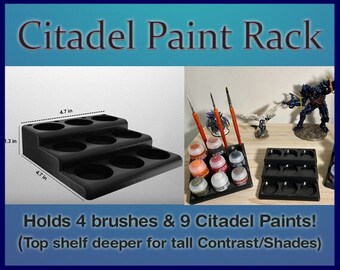 Pode incluir: Um suporte de pintura de plástico preto com três prateleiras, cada prateleira com três reentrâncias circulares para segurar garrafas de tinta. A prateleira superior é mais profunda para acomodar garrafas mais altas. O suporte comporta 9 tintas Citadel e 4 pincéis. O suporte mede 12 cm de largura e 3,3 cm de altura.