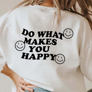 May include: White sweatshirt with black text that reads "Do what makes you happy" and three black smiley faces.