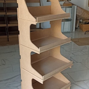 Può includere: Un espositore in legno con quattro ripiani. L'espositore è in legno grezzo e ha una parte superiore curva.