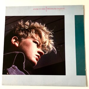 May include: Album cover for "Pressure Points" by Anne Clark. The cover features a close-up of a person with light-coloured, spiky hair, looking down. The album title and artist name are printed in red at the top.