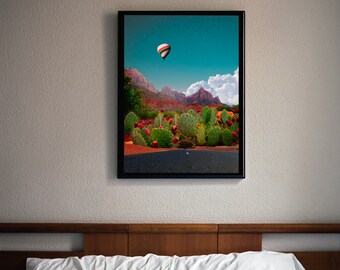 May include: A framed photograph of a hot air balloon flying over a desert landscape with cacti and red rock formations. The sky is blue with white clouds.