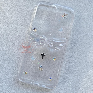 Peut inclure: Coque de téléphone transparente avec un motif d'aile d'ange argentée, une croix noire et des accents de paillettes irisées.
