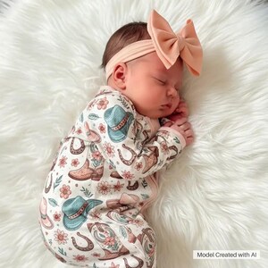 Cute western baby girl sleeper with zipper designed with charming cowboy print for little cowgirl style. This baby double zipper romper includes convertible hands and feet so it can be worn as footed pajamas or open foot jammies, making it a comfortable western outfit for baby girls, newborn photos, or baby shower gifts. Image created with AI.