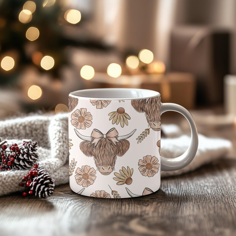 May include: White ceramic mug featuring a repeating pattern of a Highland cow with a bow, flowers, and leaves. The cow is brown with long horns. The flowers are in shades of beige and yellow. The mug has a white handle.