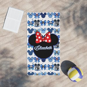 Custom Minnie Mouse themed cruise towel designed for kids with vibrant red and blue accents and personalized name detail. Ideal for Disney cruise poolside lounging, swim lessons onboard, and fun family vacation photo moments.
