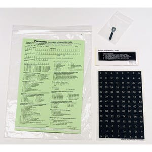 May include: A green purchase information card with a survey about a Panasonic product. A black and white keyboard sticker sheet with letters and numbers. A small black and white instruction sheet with the text "Simple Programming Steps". A small silver tool in a clear plastic bag.