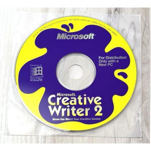 May include: A Microsoft Creative Writer 2 software CD with a yellow background and a large purple ink-blot shape. The disc features the Microsoft logo, Windows 95 branding, and the text: For Distribution Only with a New PC, Show the World Your Creative Genius.