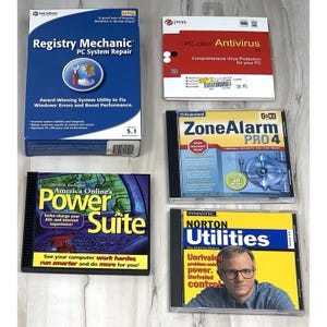 May include: A collection of five vintage software boxes and CD cases including Registry Mechanic, PC-cillin Antivirus 11, ZoneAlarm PRO 4, America Online's Power Suite, and Norton Utilities 3.0, featuring various blue, red, and yellow graphic designs.