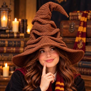 May include: A brown crocheted pointed hat with a wide brim and a textured, folded surface that creates a wrinkled appearance. The hat features a tall, slightly curved crown and a deep, structured shape crafted from yarn in a solid brown color.